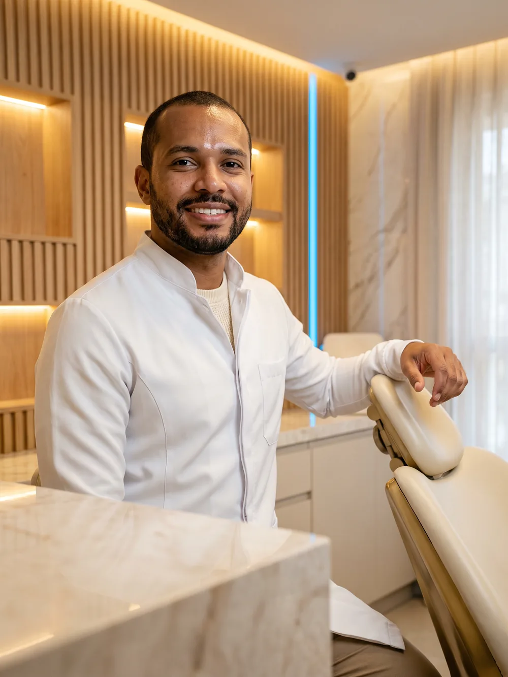 Dentista sorrindo ao lado da cadeira do consultório
